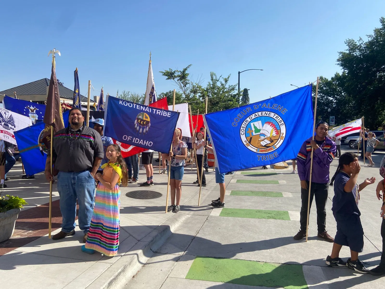 Idaho confederated tribe members walking with native american tribe flags.