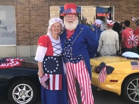 A smiling couple dressed in patriotic clothing.