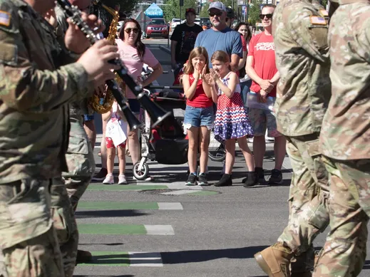 Two young girls watching passing military band